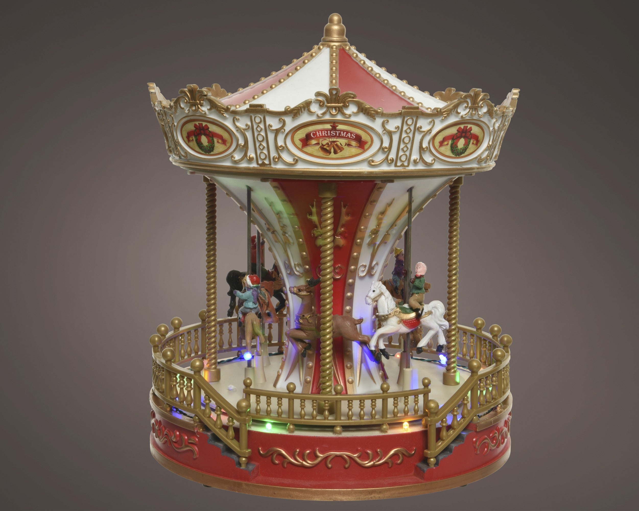 Kaemingk, Carillon Natalizio Rosso Led Multicolor 24x24x28 cm a forma di giostra carosello con cavalli, tettoia decorata con corone natalizie e scritta Christmas - DeMatteis.it