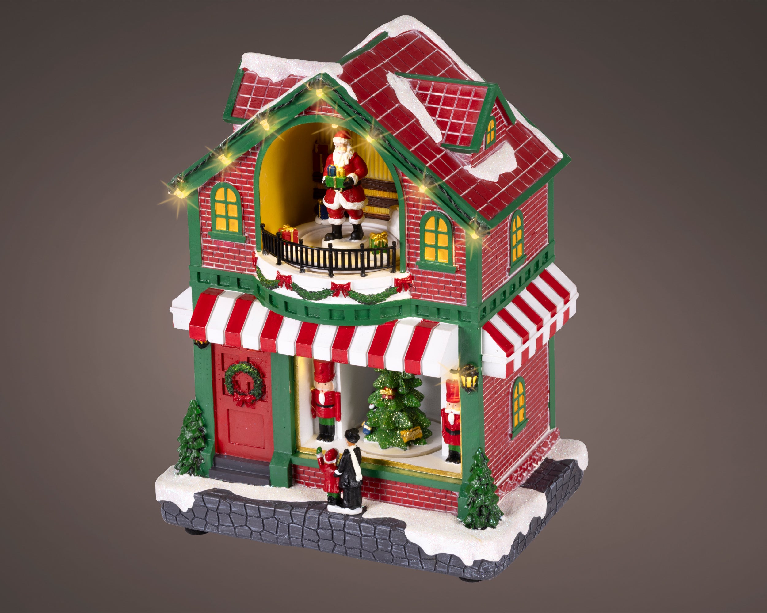 Kaemingk, Casetta Con Babbo Rossa 15x22x27 cm, ambientazione villaggio natalizio Lemax con Babbo Natale sul balcone, luci LED, schiaccianoci e albero decorato al piano terra - DeMatteis.it