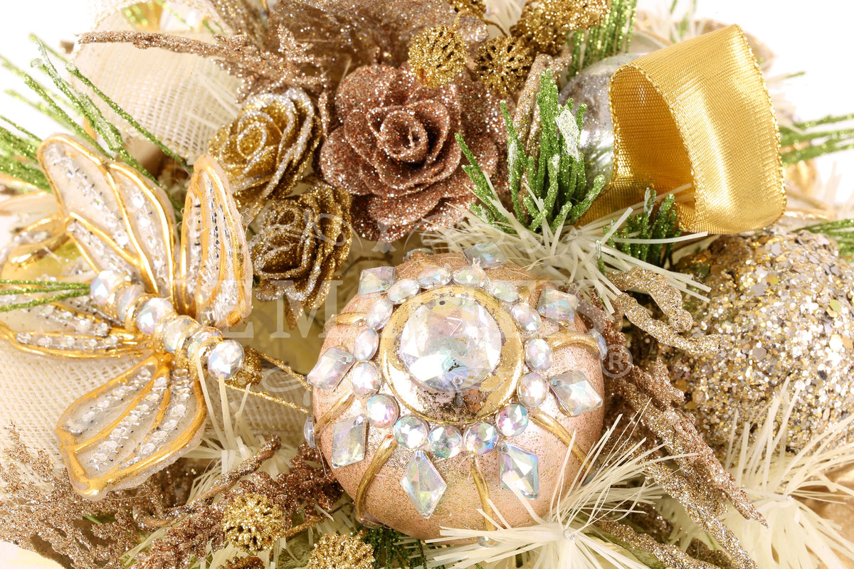 De Matteis, Dettaglio centrotavola ovale champagne oro con rose glitterate, candela decorativa con strass, nastri dorati e rametti verdi glitterati - DeMatteis.it