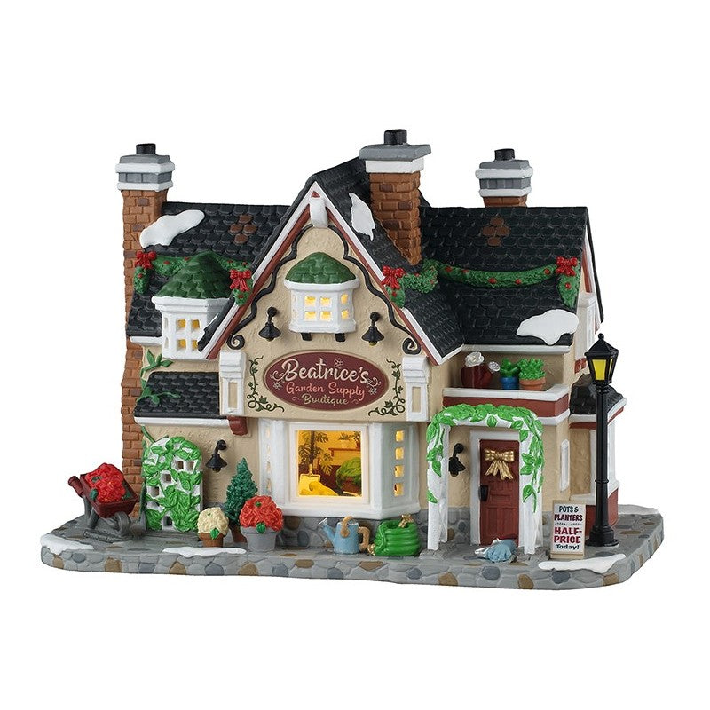 Beatrice's Garden Supply Boutique Lemax: casa vittoriana illuminata con camini in mattoni per Villaggio Natale Lemax, decorata con ghirlande e vasi di fiori. | Dematteis.it
