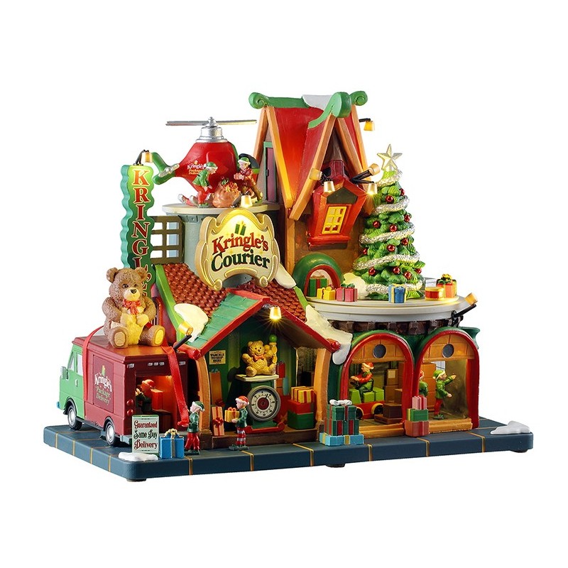 Kringle's Courier Lemax edificio spedizioni Villaggio Natale con elfi lavoratori, camion consegne e albero illuminato | Dematteis.it