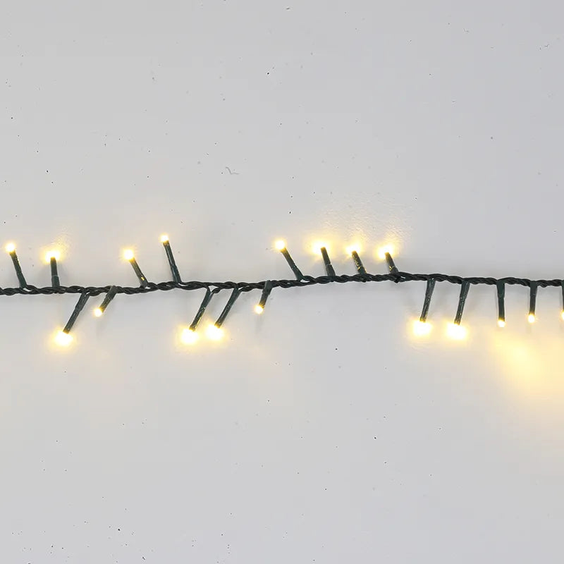 De Matteis, Luci Natale 500 Led 10 m reversibili caldo freddo con cavo verde scuro e luci LED bianco caldo accese su sfondo neutro - DeMatteis.it