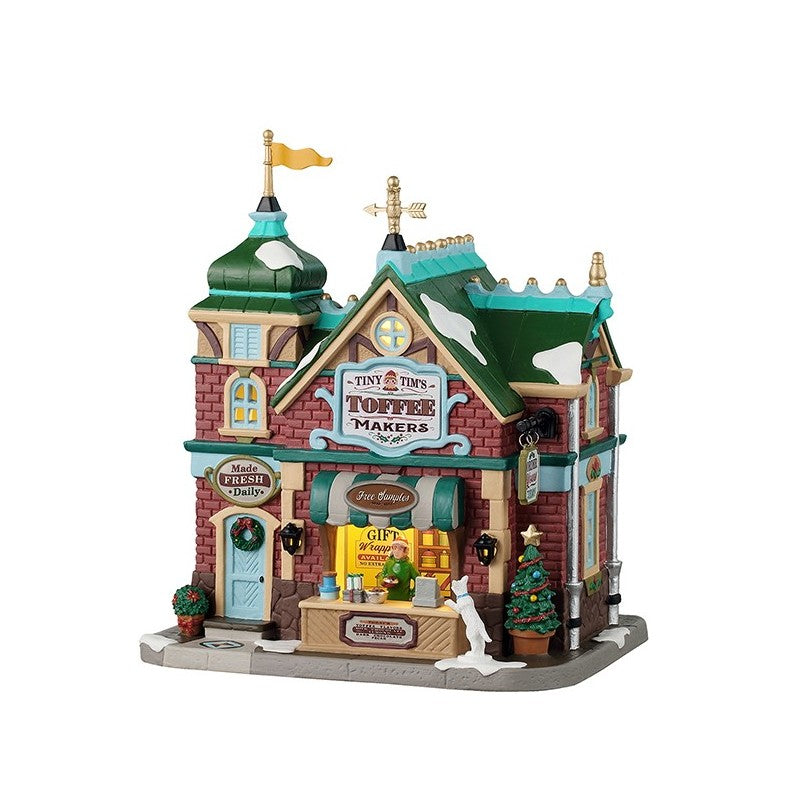 Tiny Tim's Toffee Makers Lemax edificio vittoriano del Villaggio Natale Lemax con torre verde acqua, mattoni rossi e stand esterno illuminato per degustazioni toffee artigianali | Dematteis.it