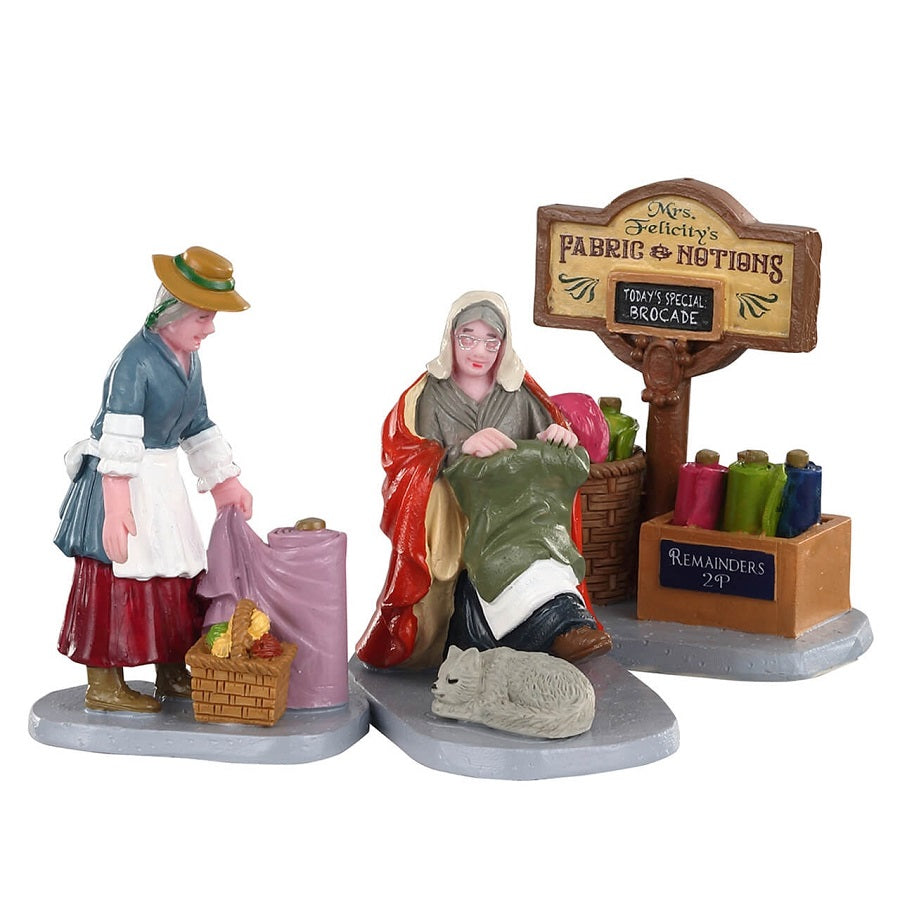 Fabric Vendor Set Of3 Lemax figurine decorative per villaggio natalizio con venditrice di tessuti e accessori - DeMatteis.it