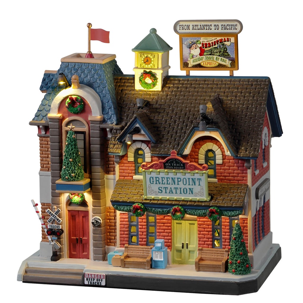 Greenpoint Station Lemax stazione ferroviaria vittoriana illuminata con torre dell'orologio, decorazioni natalizie e cartellone pubblicitario per Villaggio di Natale. | Dematteis.it