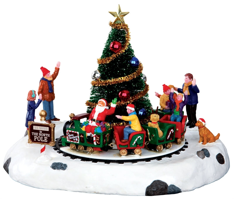 Santa's Kiddie Train Lemax con albero di Natale decorato, trenino rotante rosso e verde, Babbo Natale e bambini su base innevata per villaggio Lemax - Dematteis.it