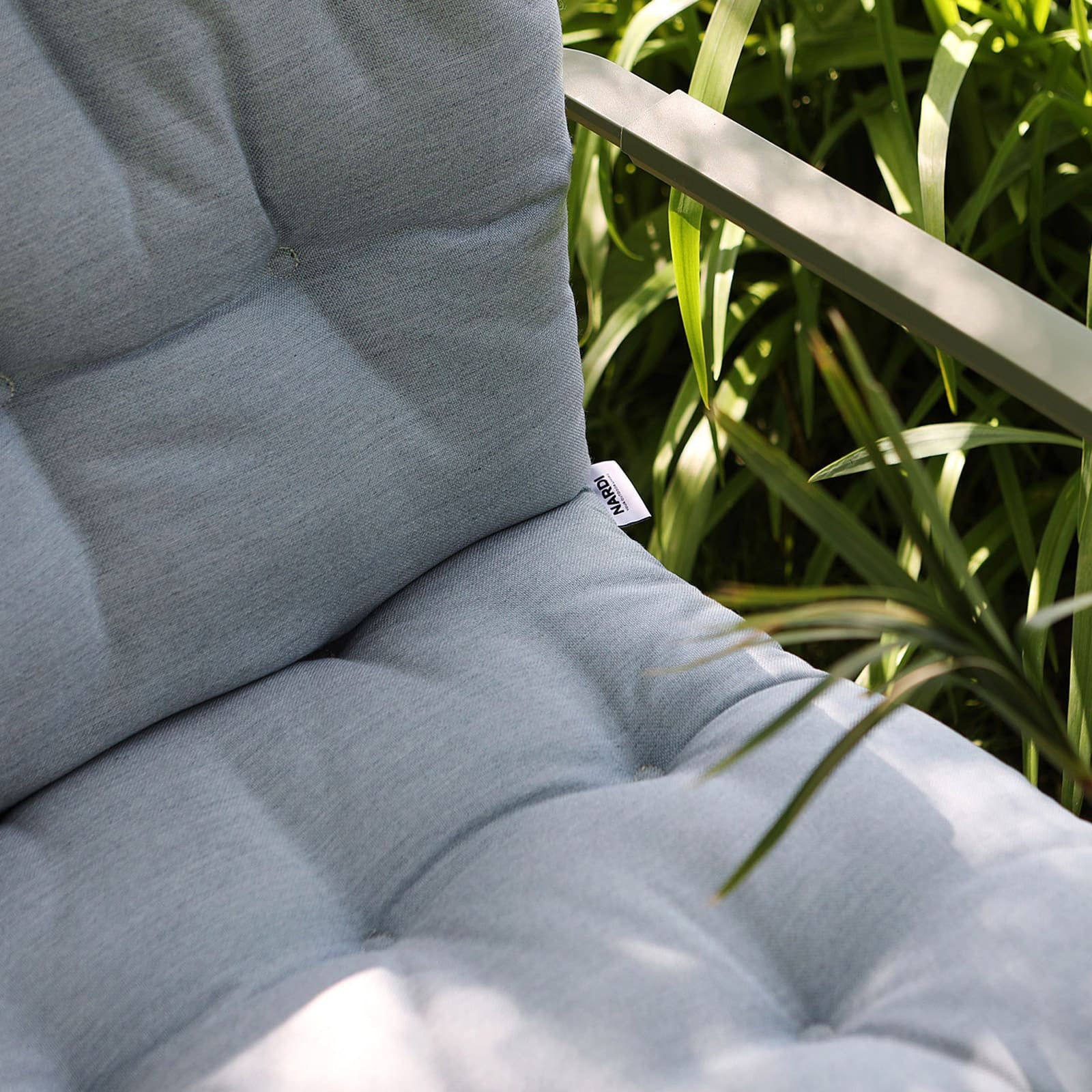 Nardi Outdoor, Cuscino Folio Confort Artic Sunbrella in tessuto grigio chiaro con texture trapuntata applicato su sedia da esterno in ambiente giardino - DeMatteis.it