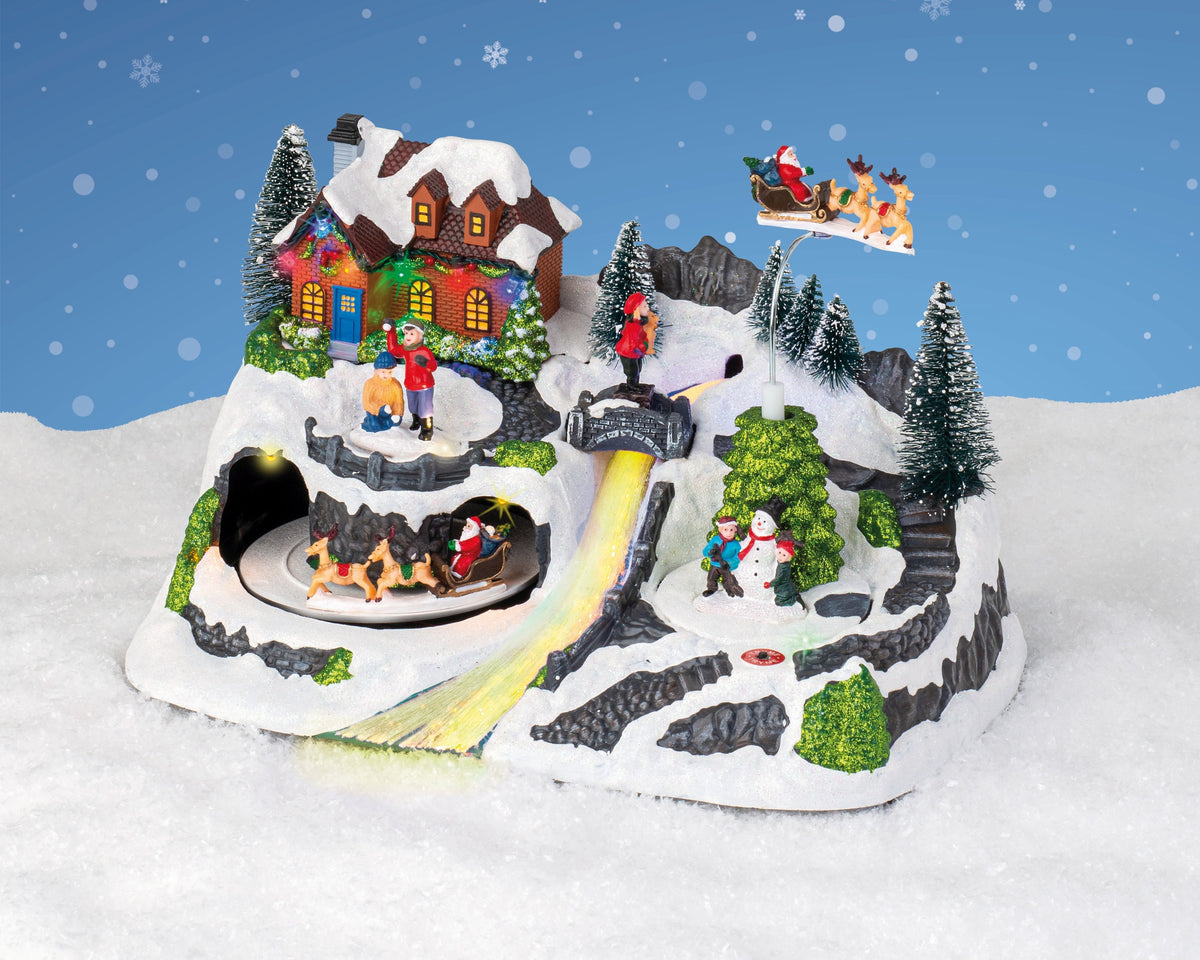 Kaemingk, Villaggio Natalizio Innevato 31x20x30 cm con casa illuminata, slitta di Babbo Natale, pupazzo di neve e pista luminosa animata - DeMatteis.it