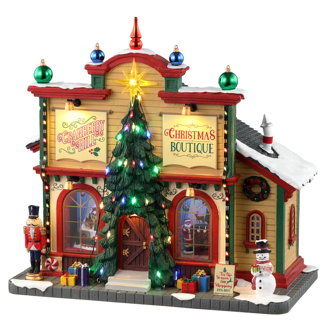 Cranberry Hill Christmas Boutique Lemax: negozio natalizio illuminato a due piani con tetto rosso innevato, albero di Natale centrale e decorazioni festive per villaggio di Natale Lemax | Dematteis.it