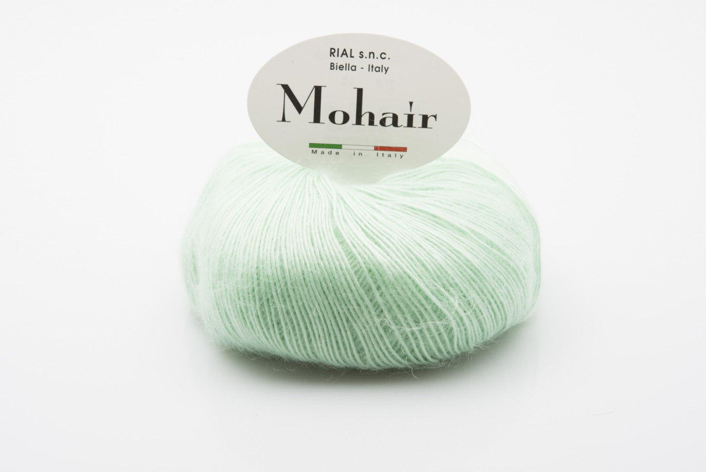 Rial, Filato Mohair 50 g Colore 18 gomitolo verde menta chiaro con texture soffice e pelosa e fascetta ovale con scritta Mohair Made in Italy - DeMatteis.it