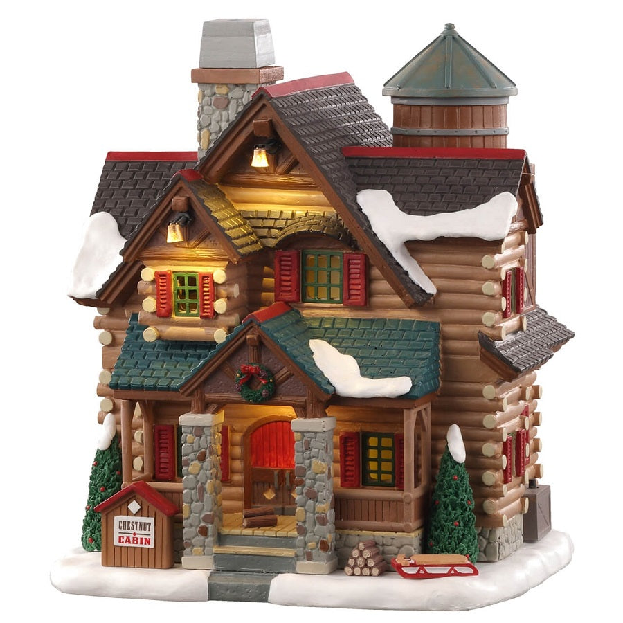 Chestnut Cabin Lemax casa di montagna illuminata con tronchi di legno, tetti innevati, camino fumante e finestre luminose per villaggio Lemax. | dematteis.it