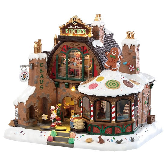 Mrs Claus' Kitchen Lemax: cucina natalizia animata a forma di casa pan di zenzero con elfi in movimento, finestre illuminate e decorazioni candy cane per villaggio di Natale. | Dematteis.it