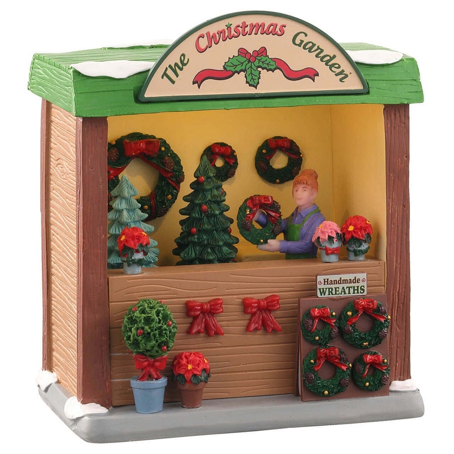 Bancarella Lemax The Christmas Garden con figurina femminile che realizza ghirlande natalizie, stelle di Natale in vasi e decorazioni per villaggio Lemax. | Dematteis.it